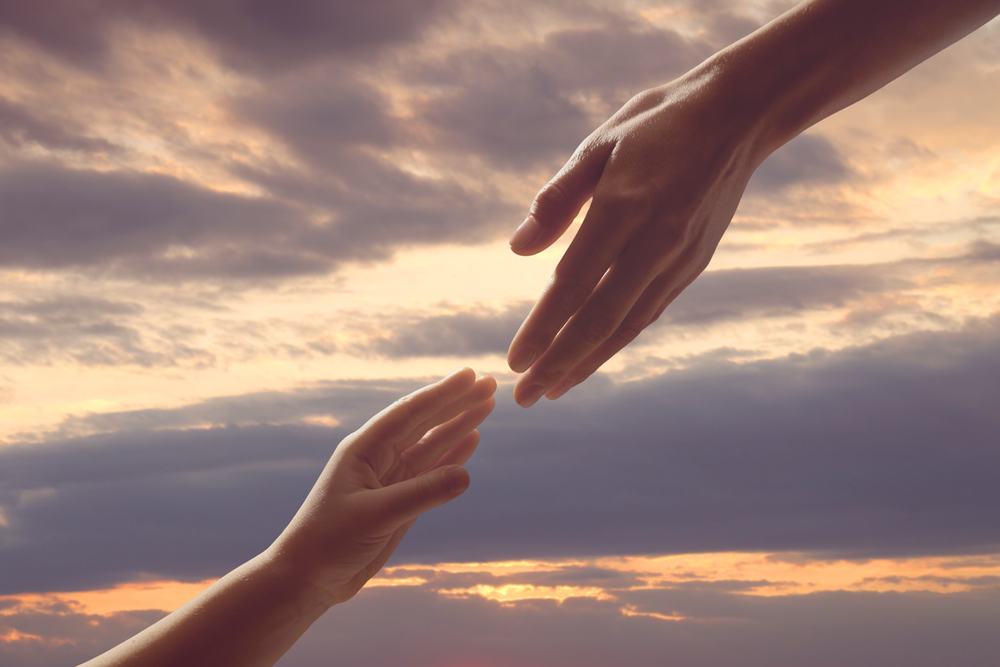 Woman with child on black background, closeup of hands